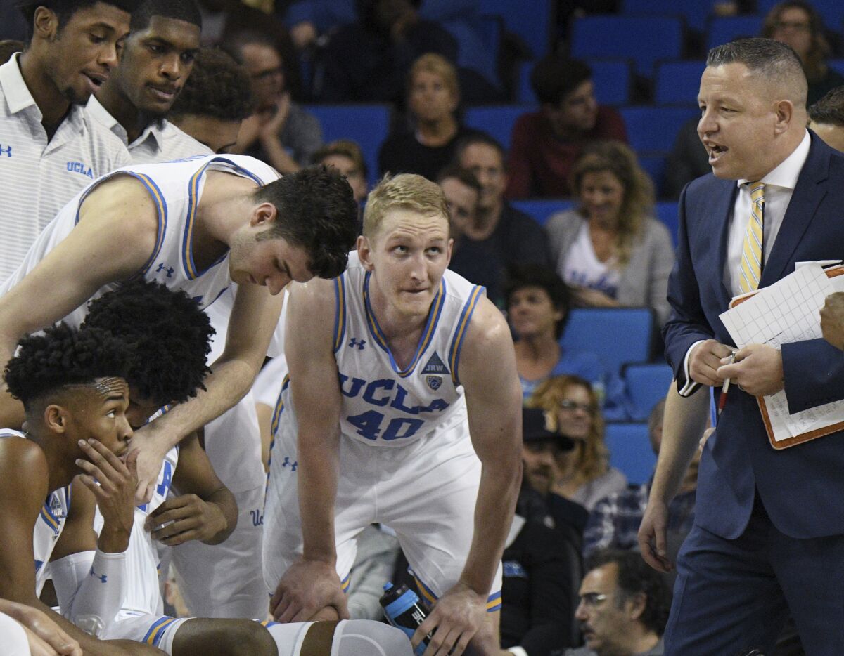 UCLA assistant coach David Grace talks to players during a timeout