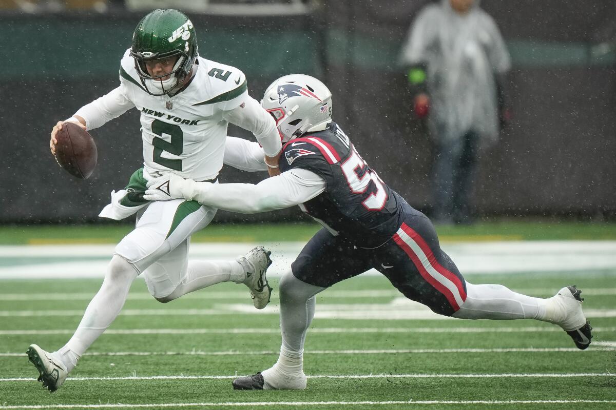 The Jets' Zach Wilson is tackled during a game.