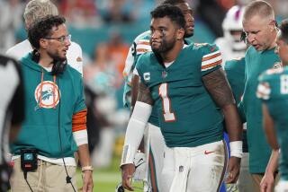 Miami Dolphins head coach Mike McDaniel talks to quarterback Tua Tagovailoa (1) as he leaves the game.