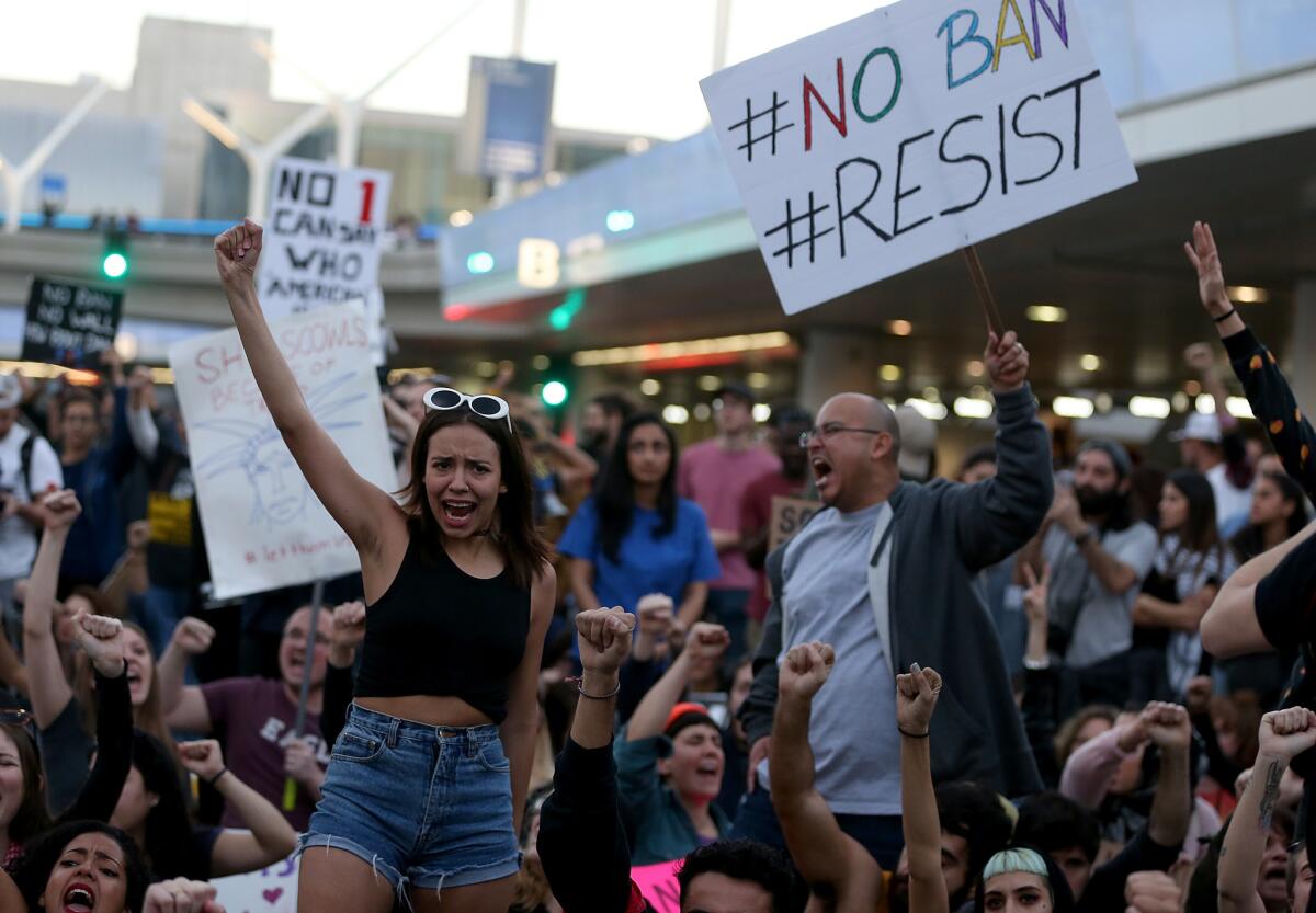 Demonstrators hold signs as they block a road at Los Angeles International Airport to protest President Trump's travel ban, which was later blocked by the courts.