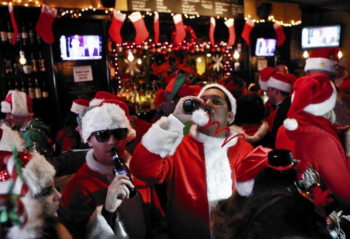 Revelers dressed as Santa Claus in New York City's East Village during the annual SantaCon bar crawl, which has some city residents concerned about public rowdiness.