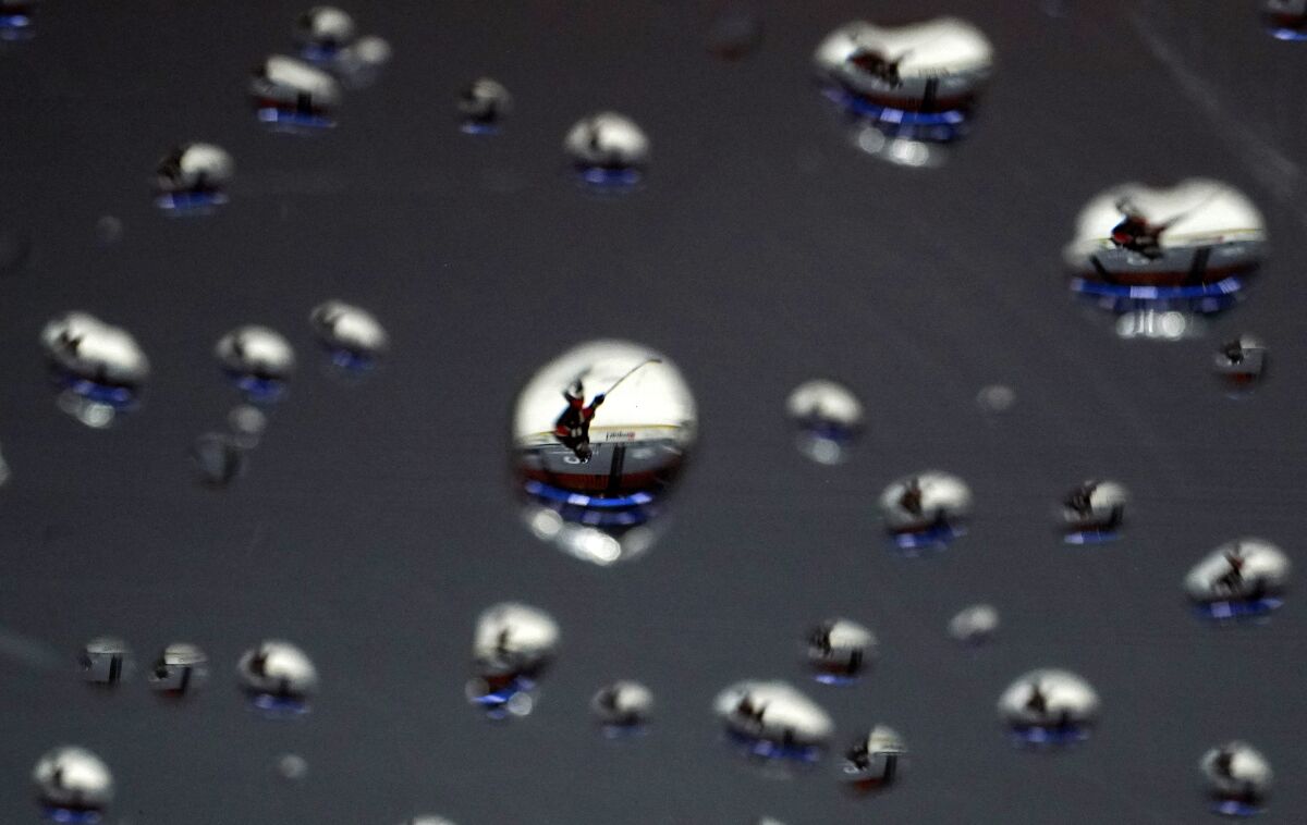 FILE - A member of the Anaheim Ducks skates by the glass after it had been sprayed by water during the second period of an NHL hockey game against the San Jose Sharks Saturday, March 13, 2021, in Anaheim, Calif. The photo was part of a series of images by photographer Mark J. Terrill which won the Thomas V. diLustro best portfolio award for 2021 given out by the Associated Press Sports Editors during their annual winter meeting.(AP Photo/Mark J. Terrill, File)
