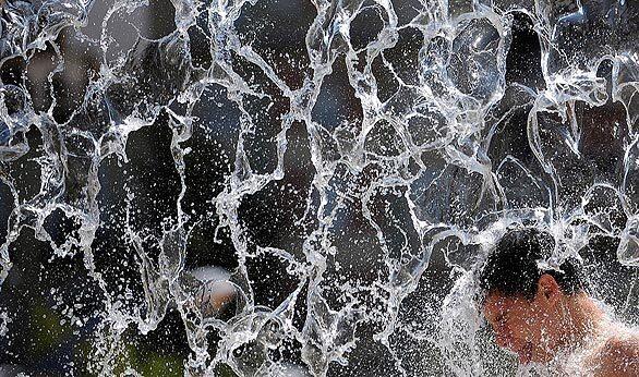 A boy cools himself in a fountain in Cordoba, southern Spain.