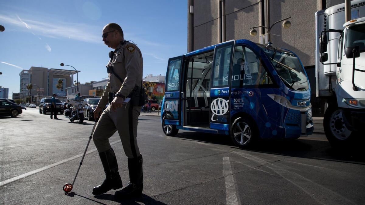 A police officer works the scene of an accident between a self-driving shuttle and a truck in downtown Las Vegas on Nov. 8. The accident occurred just hours after the automated ride service was launched.