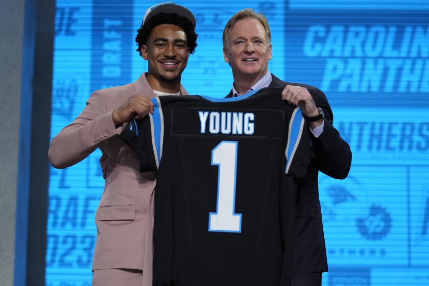 Alabama quarterback Bryce Young gets a jersey from NFL Commissioner Roger Goodell.