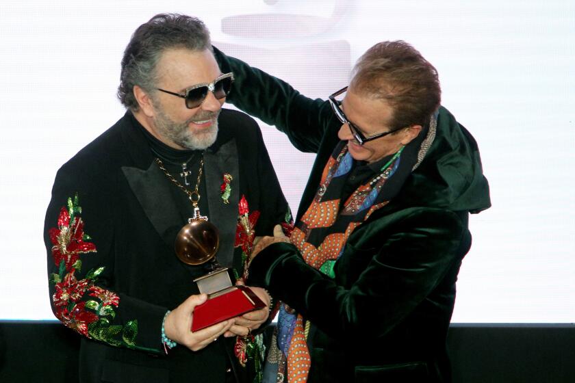 Mexican composer and singer Emmanuel, right, presented fellow Mexican singer Mijares the Lifetime Achievement Award
