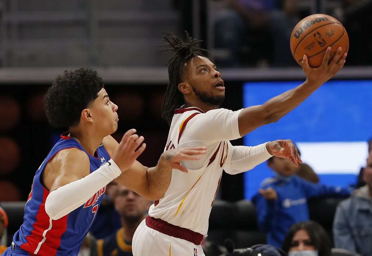 Cavaliers guard Darius Garland attempts a layup while defended by Pistons guard Killian Hayes.
