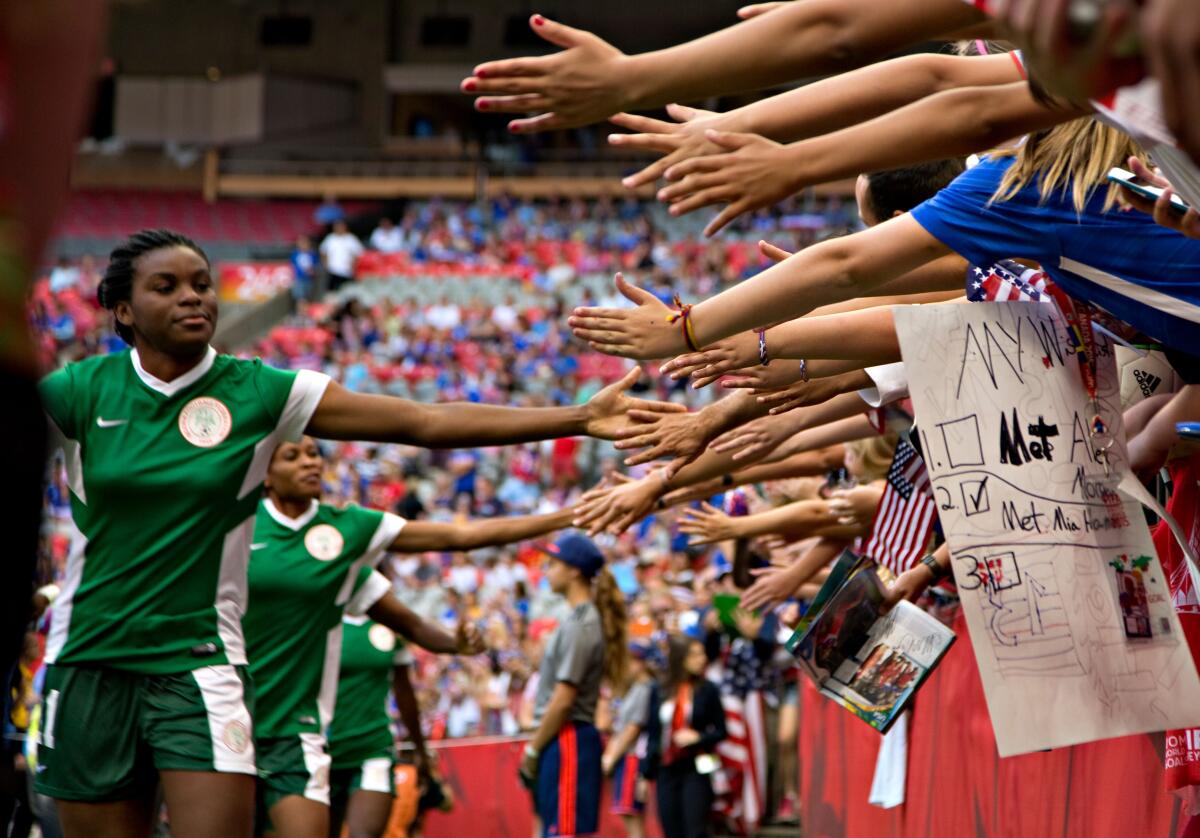 Nigeria forward Ini-Abasi Umotong greets fans before a match against the United States during the 2015 Women's World Cup.