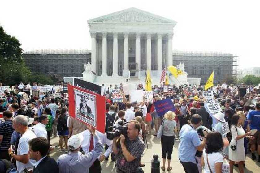 Supporters and foes of President Obama's healthcare program gather in front of the U.S. Supreme Court last month to find out the high court's ruling.