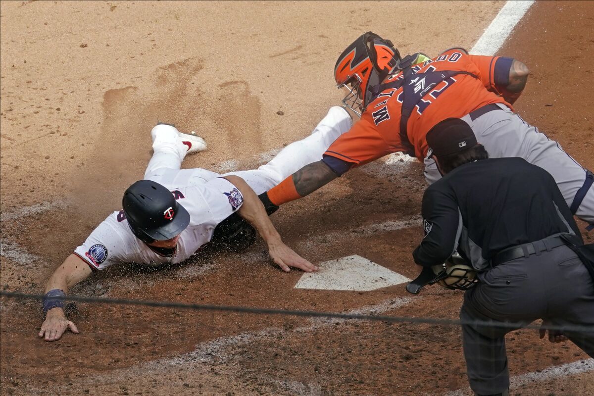 Minnesota Twins' Max Kepler beats the tag by Houston Astros catcher Martin Maldonado.