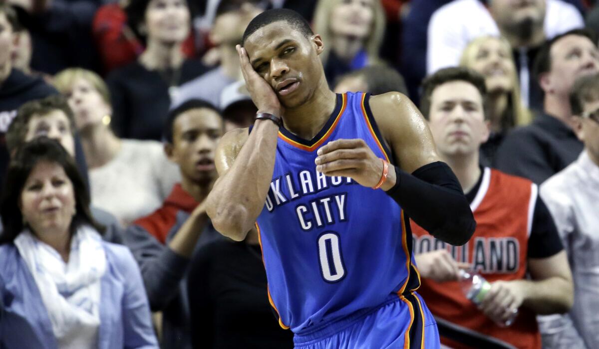 Oklahoma City Thunder point guard Russell Westbrook holds his cheek during the final seconds of the game against the Trail Blazers on Friday night in Portland.