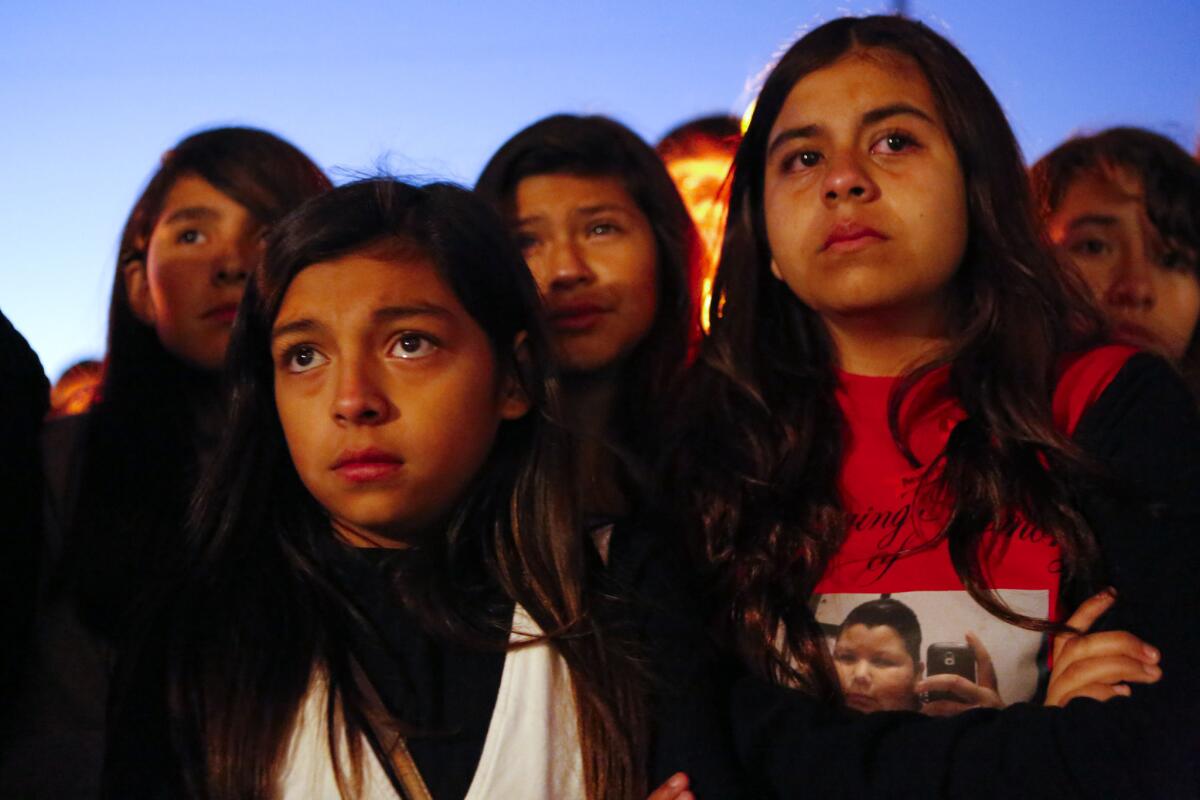 A young girl wears a T-shirt in memory of 13-year-old Angela Sandoval as friends and classmates of Sandoval hold a candlelight vigil at Eastmont Intermediate School on Monday in Montebello. Sandoval was one of five killed Saturday morning.