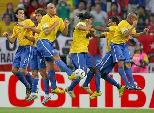 Brazilian players Kaka, Juninho, Ronaldo, Ronaldinho, Ze Roberto and Roberto Carlos are up in the air during a French free kick.