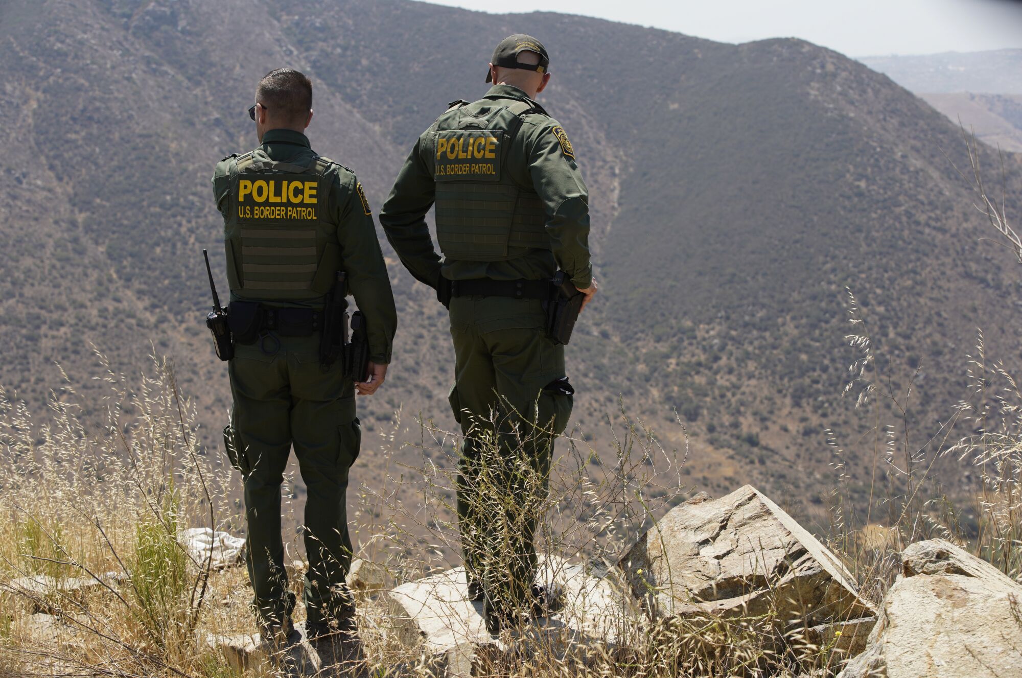Border Patrol agents Jeff Stephenson and Jacob Macisaac look down from Otay Mountain