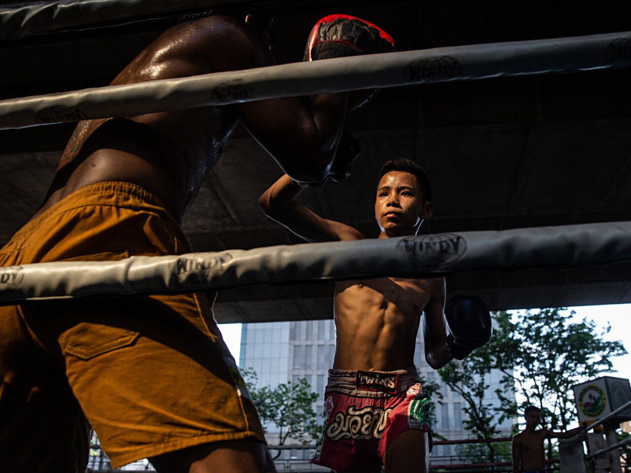 Pheearanut Saleephol, 14, spars against his trainer, Jamlong Jaipakdee,50, at the Sor. Pullsawas Gym in Bangkok, Thailand on Monday April 8, 2019. Thai Boxing, locally known as Muay Thai, is considered to be the national sport of Thailand, with children as young as 8 years old competing professionally. In recent years, allowing children under the age of 15 to compete has become controversial due to potential health risks. Pheearanut has been boxing since age 12. His adoptive father and grandfather boxed professionally in their youth and he decided to follow in their footsteps. Photo by Lauren DeCicca