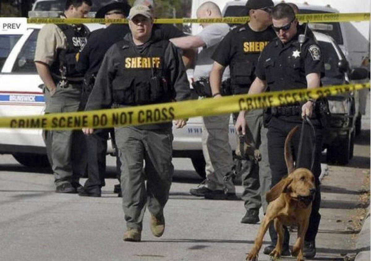 Authorities investigate the scene of the shooting in Brunswick, Ga.