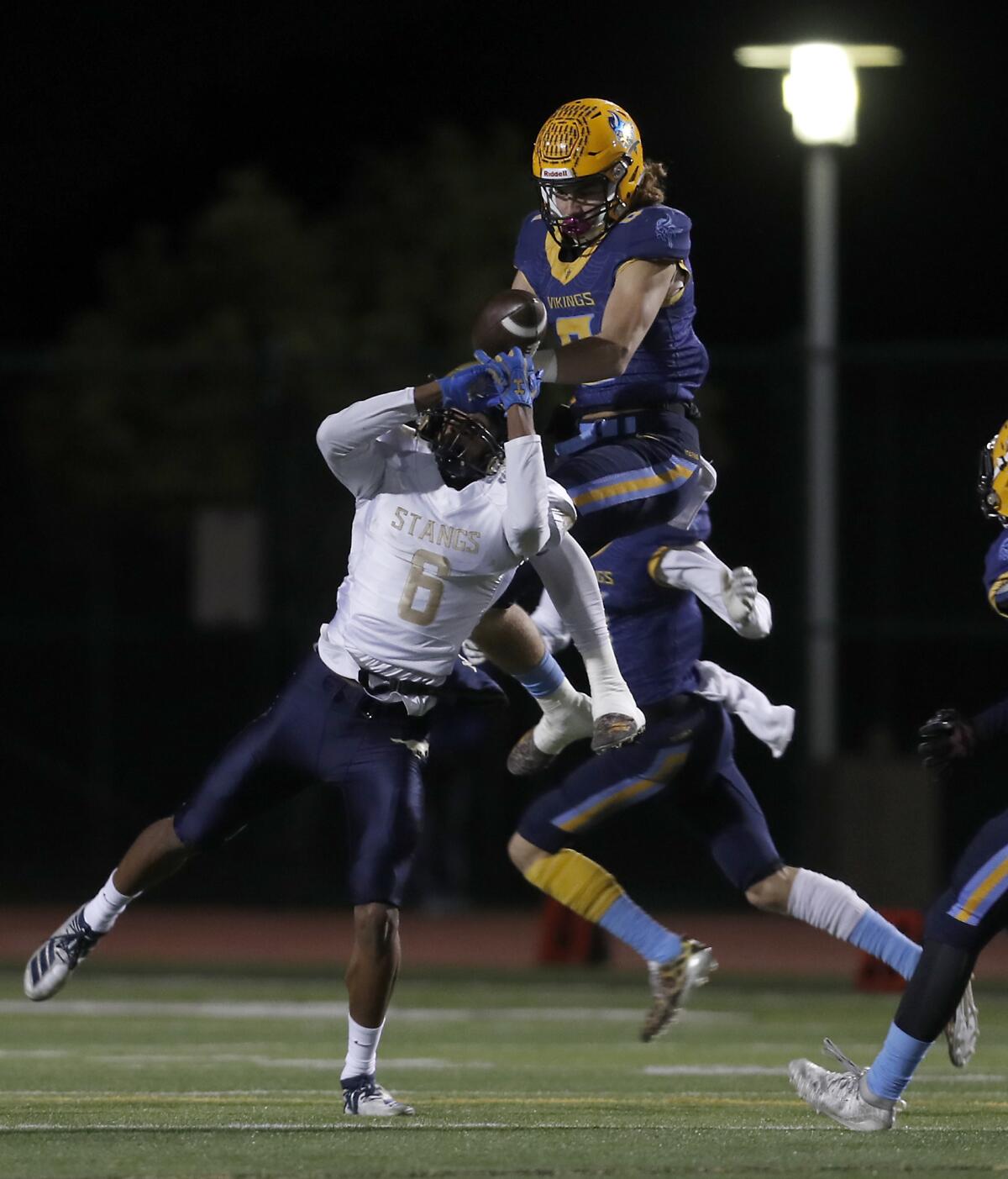 Marina’s Dane Brenton, top, breaks up a pass intended for Muir’s John Humphrey, left, and Eric Church, not pictured, intercepts it in the CIF Southern Section Division 11 title game on Nov. 29 at Westminster High.