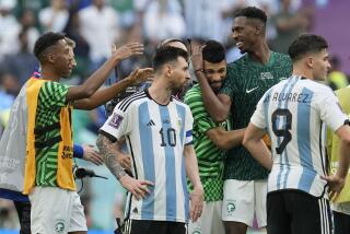 Argentina's Lionel Messi standing beside Saudi Arabia's players celebrating after winning the World Cup group C soccer match