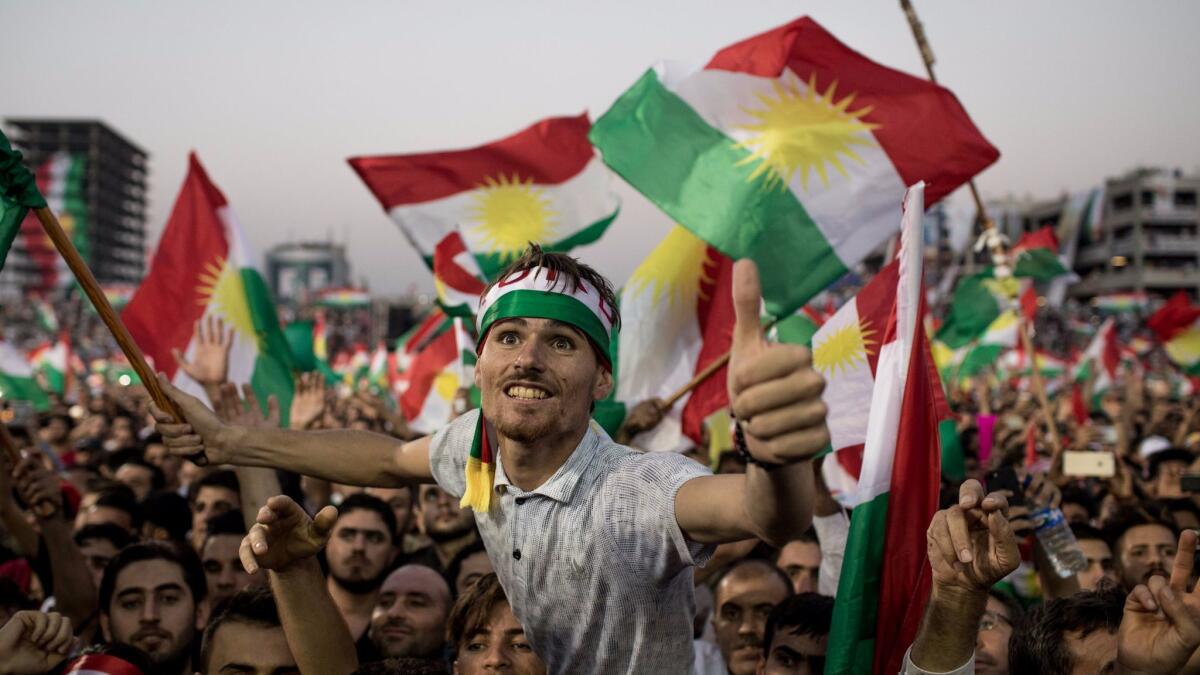 Supporters of Kurdish leader Masoud Barzani wave flags and chant slogans at a rally in Irbil, Iraq, for an upcoming vote on independence.
