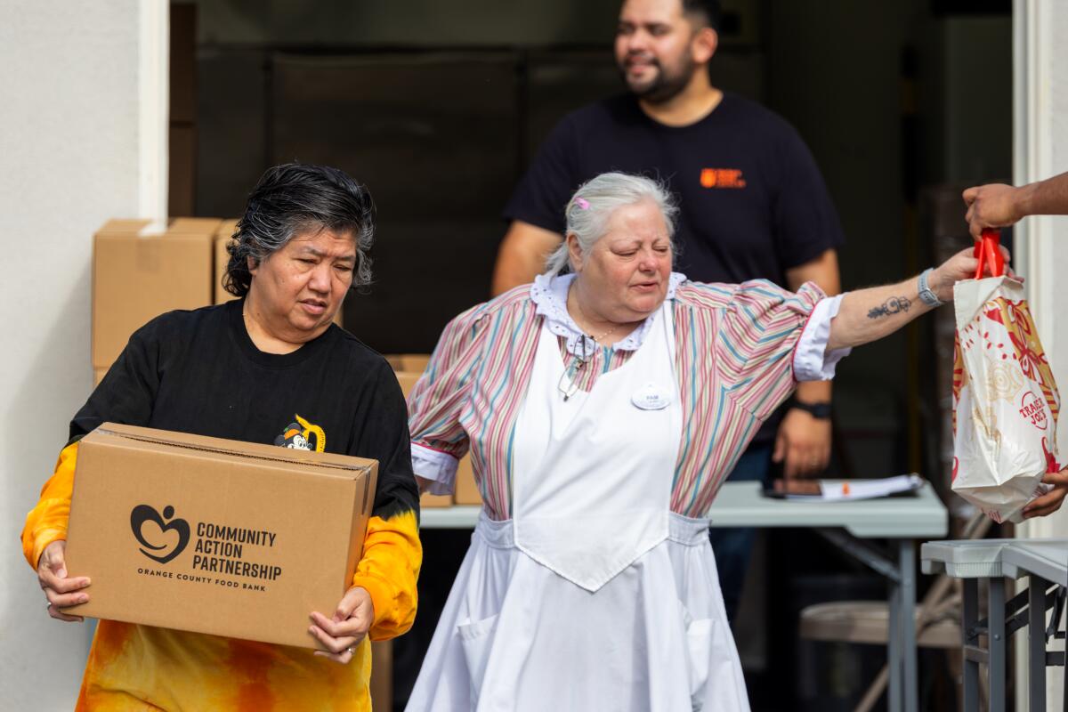 Two women collect groceries from a union-sponsored food bank for Disney workers.