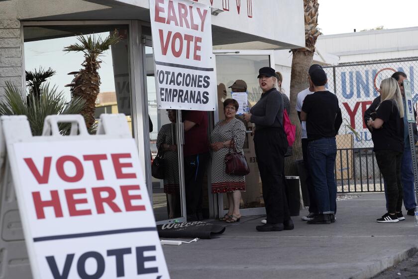 FILE - In this Feb. 15, 2020, file photo, people wait in line at an early voting location at the culinary workers union hall in Las Vegas. A businessman is facing criminal charges of voting twice in the November 2020 election, including voting with his dead wife's ballot. Nevada state Attorney General Aaron Ford announced Thursday, Oct. 21, 2021, that Donald "Kirk" Hartle faces felony charges that could get him up to eight years in prison (AP Photo/John Locher, File)