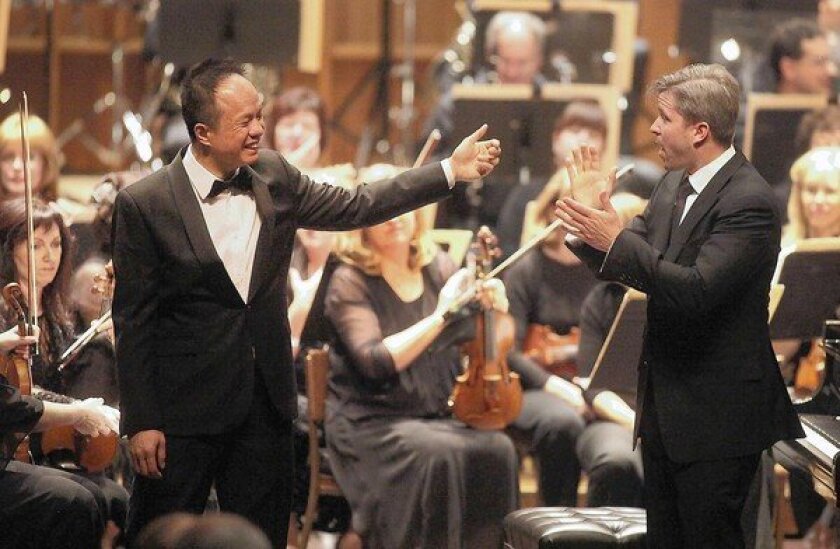 Pianist Rueibin Chen, left, and conductor Edwin Outwater, right, take in applause at the Ambassador Auditorium in Pasadena.