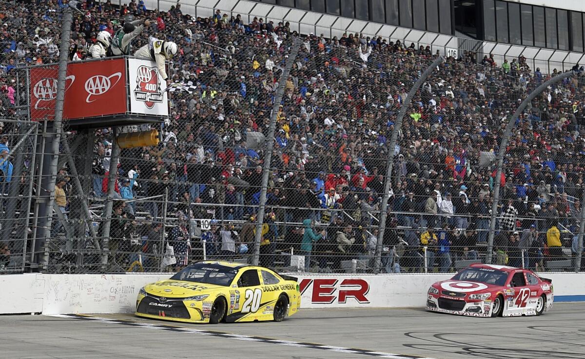 Matt Kenseth (20) takes the checkered flag ahead of Kyle Larson (42) to win the NASCAR Sprint Cup series race at Dover International Speedway on May 15.