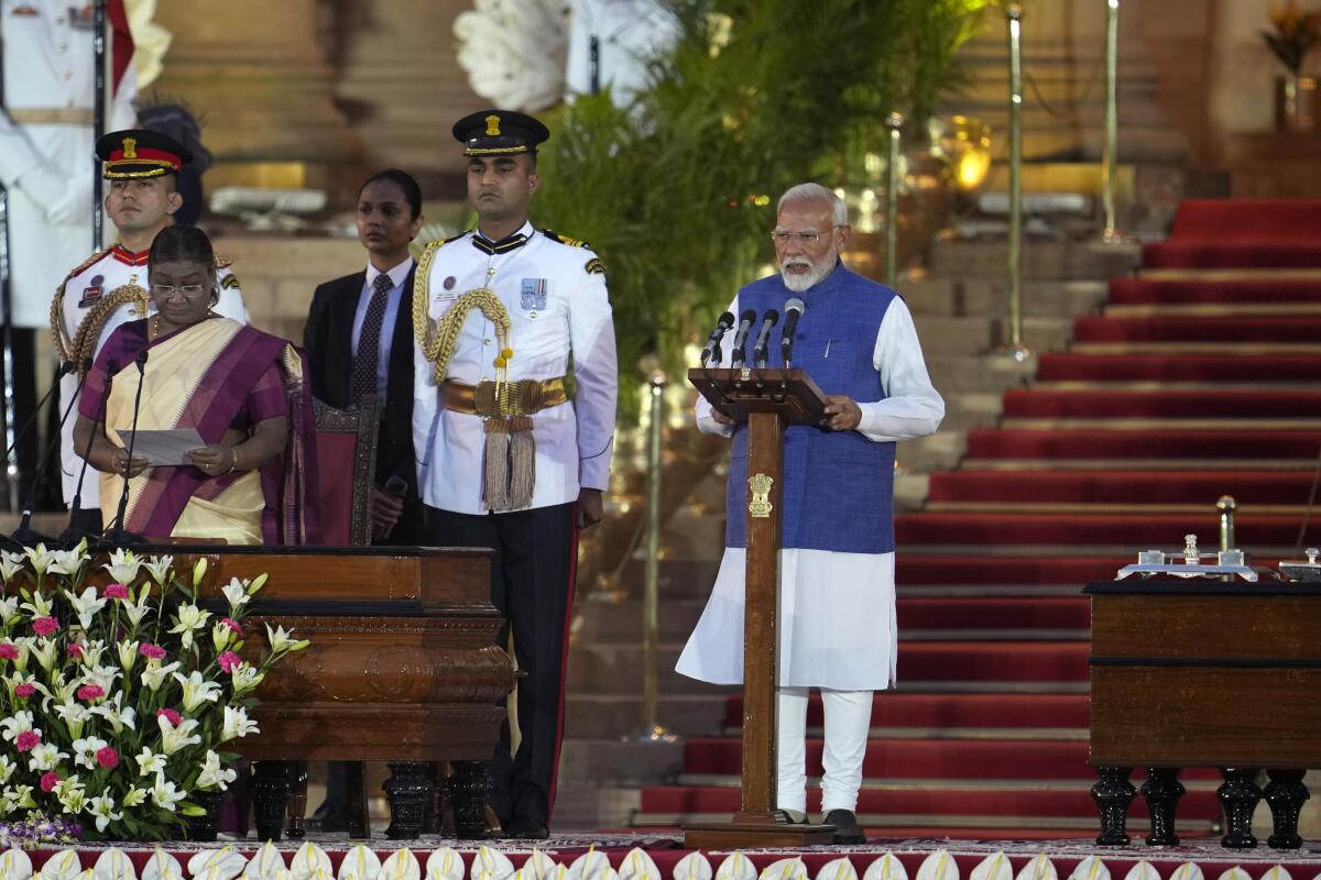 Narendra Modi, right, is sworn-in as the prime minister of India by President Droupadi Murmu, left.