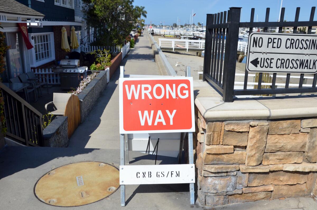 A "wrong way" sign on North Bay Front on Balboa Island last weekend notifies people of the one-way restriction on the island's wraparound walkway.