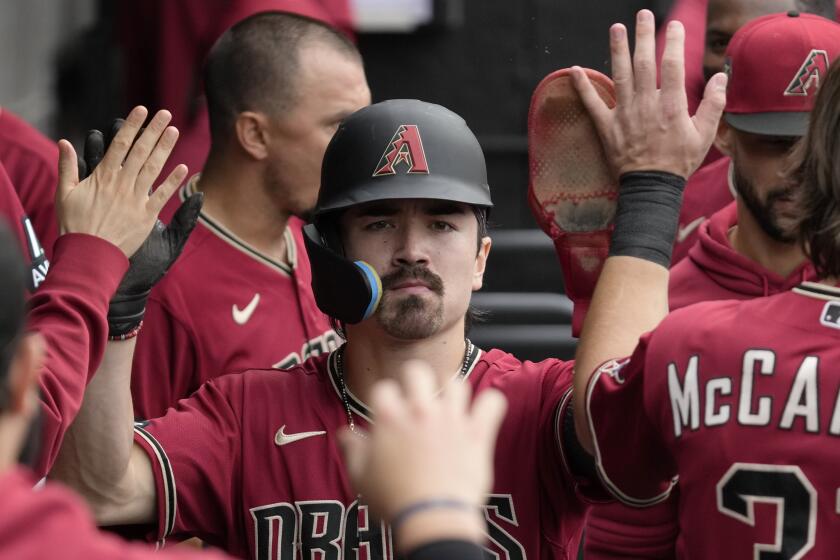 Arizona Diamondbacks' Corbin Carroll celebrates with teammates after scoring on a one-run single by Tommy Pham during the third inning of a baseball game against the Chicago White Sox in Chicago, Wednesday, Sept. 27, 2023. (AP Photo/Nam Y. Huh)