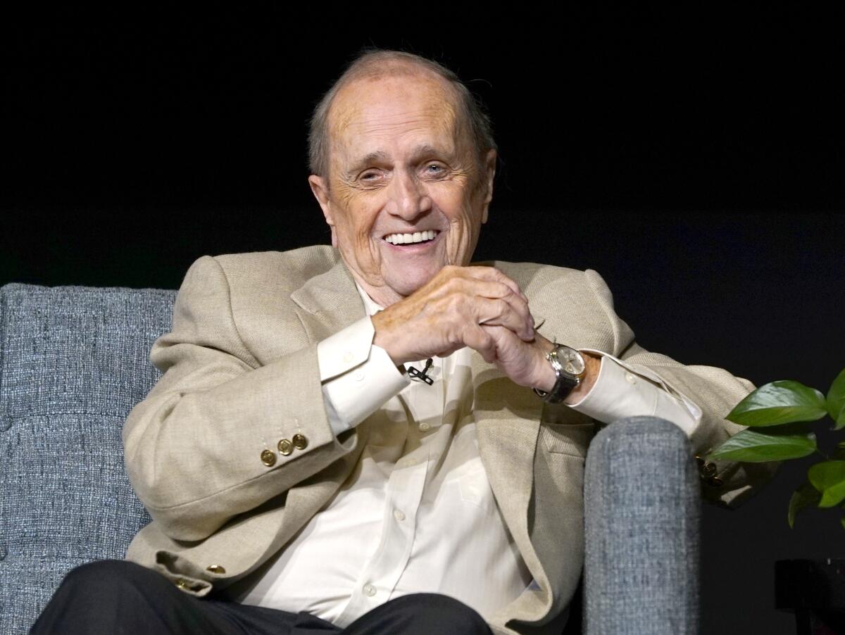 Bob Newhart sitting on a couch and laughing