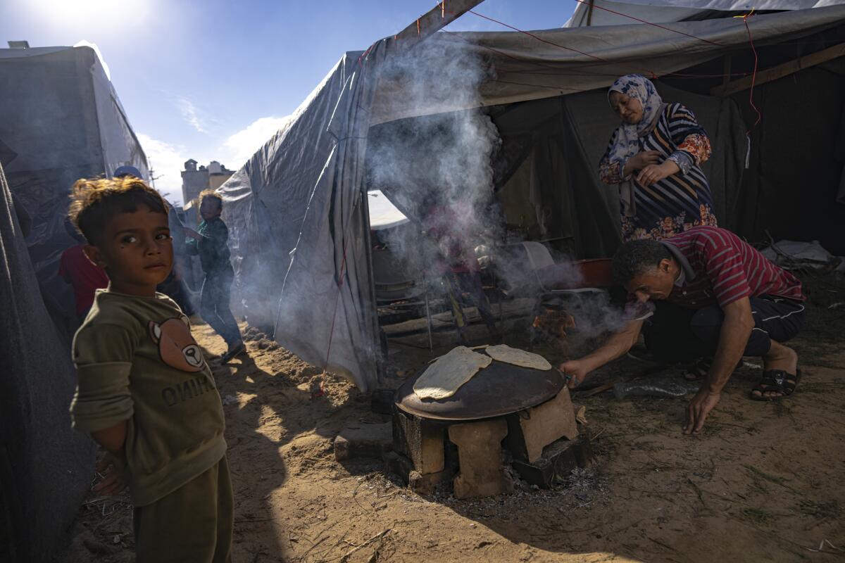 Palestinos desplazados por los bombardeos israelíes en la Franja de Gaza preparan pan