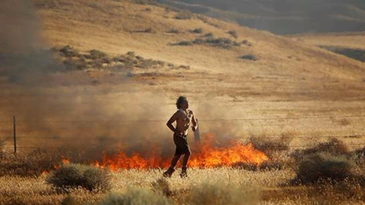 A man suspected of starting fires in Neenach is seen running away from flames.