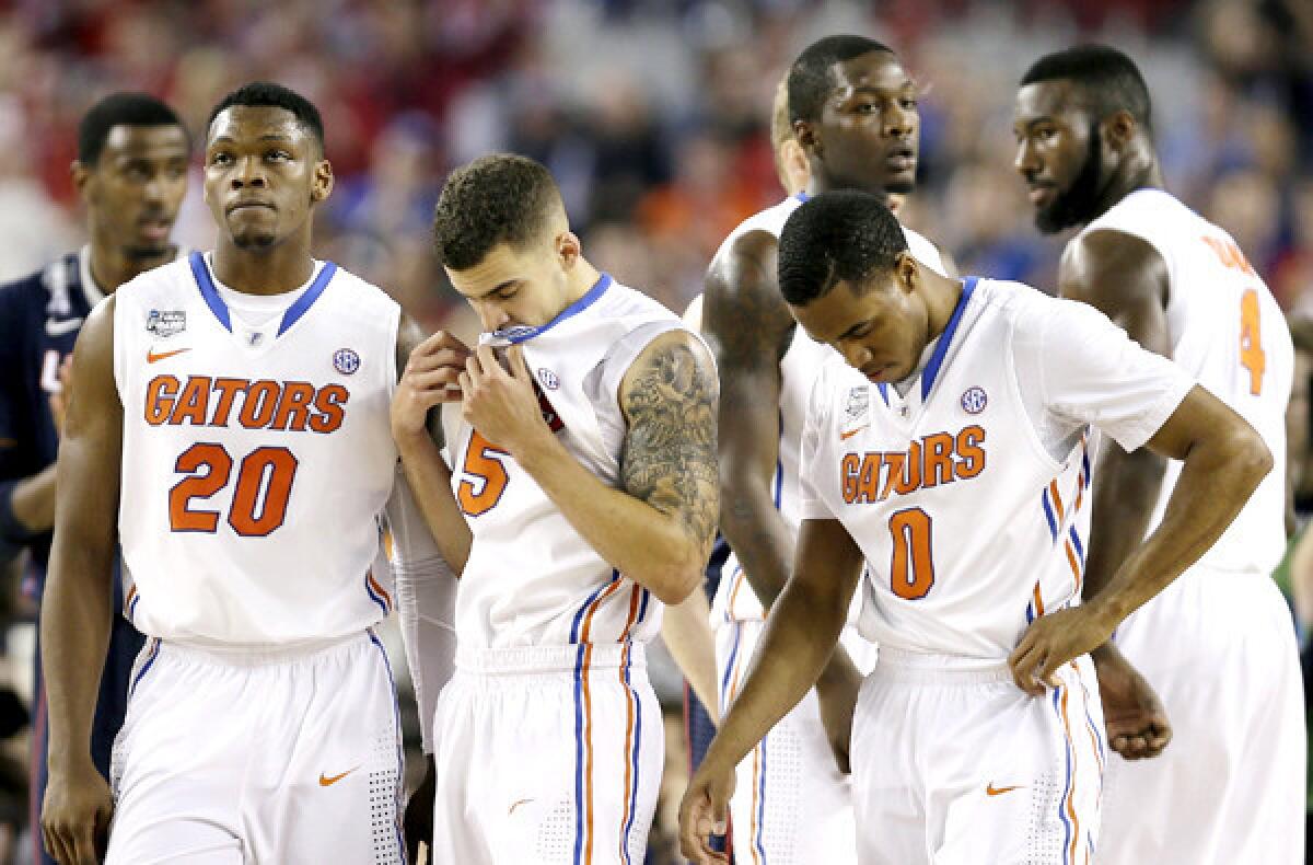 Florida players Michael Frazier II (20), Scottie Wilbekin (5) and Kasey Hill (0) react in the final moments of their Final Four loss to Connecticut on Saturday night.
