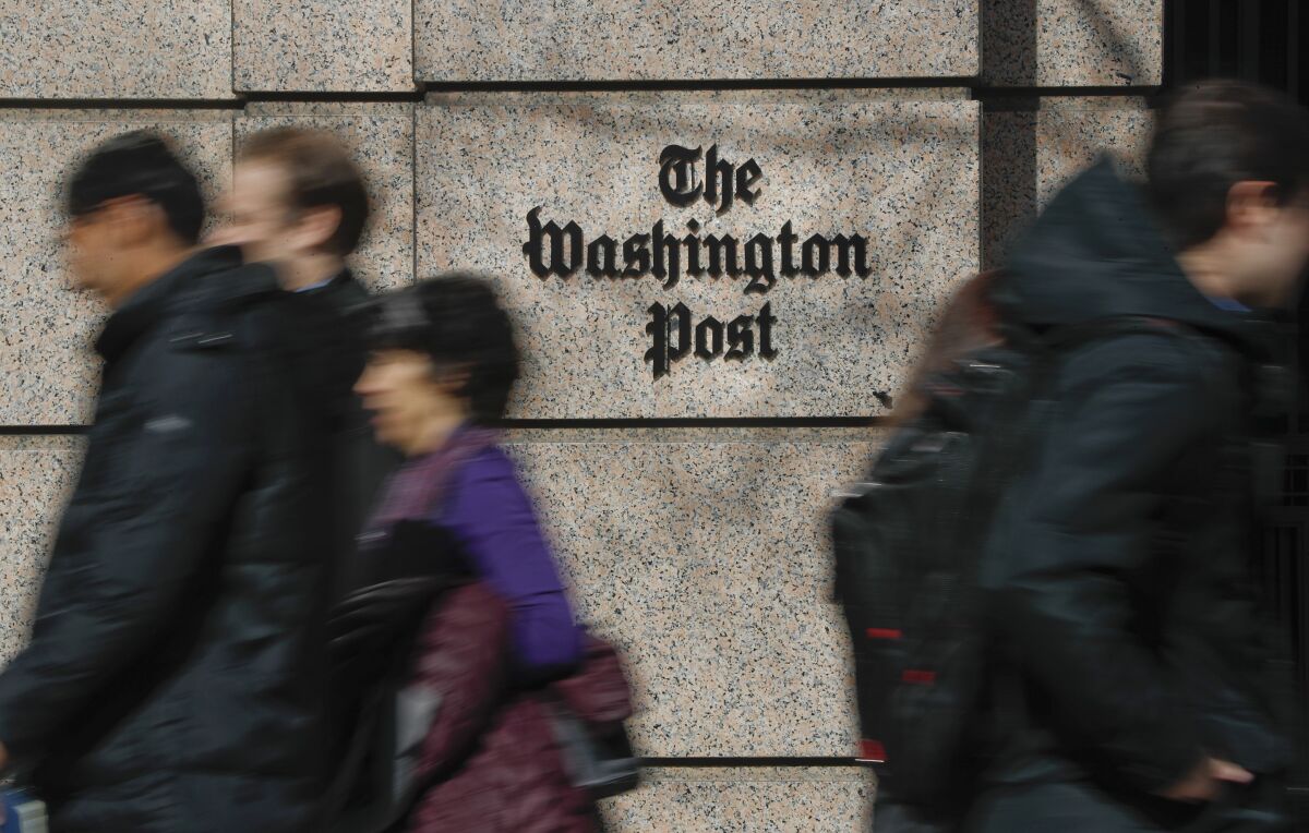 FILE - People walk by the One Franklin Square Building, home of The Washington Post newspaper, in downtown Washington on Feb. 21, 2019. The Washington Post has fired reporter Felicia Sonmez, who has triggered a vigorous online debate this past week over social media policy and public treatment of colleagues. (AP Photo/Pablo Martinez Monsivais, File)