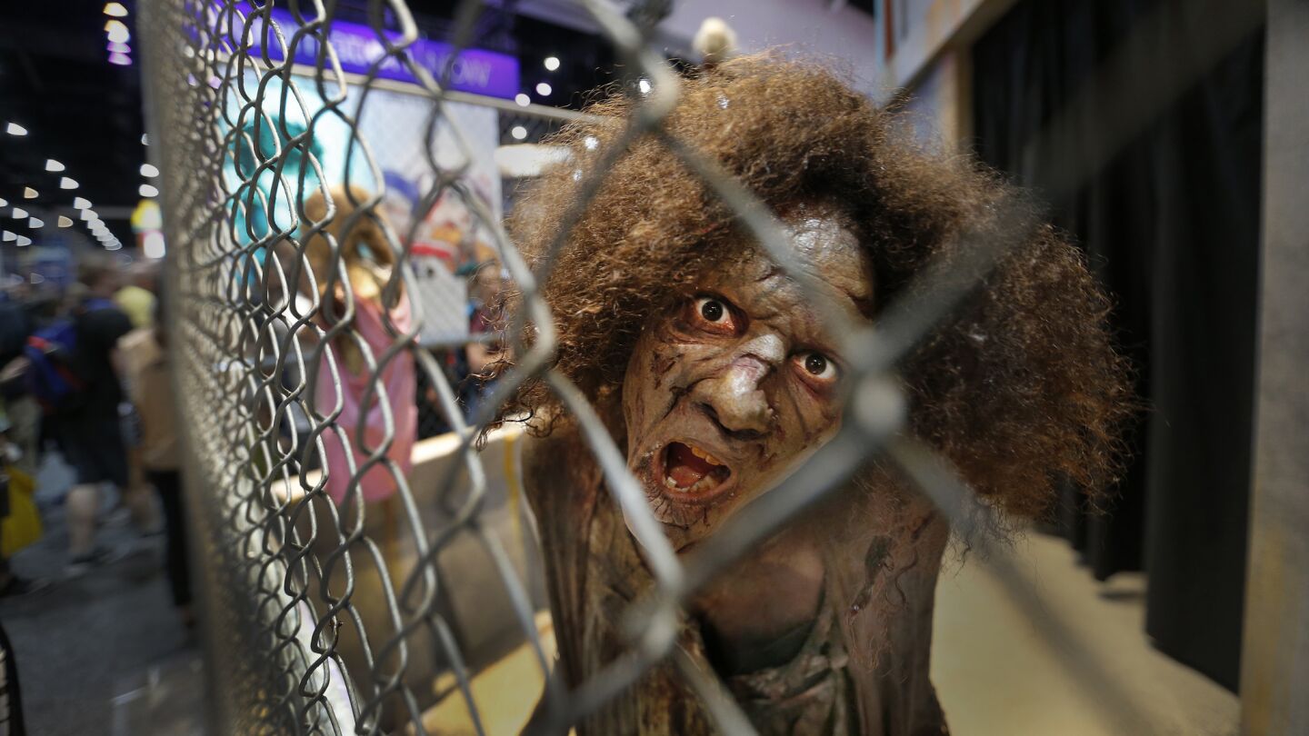 A zombie from the AMC series "Walking Dead" approaches visitors on opening day of Comic-Con International 2017.