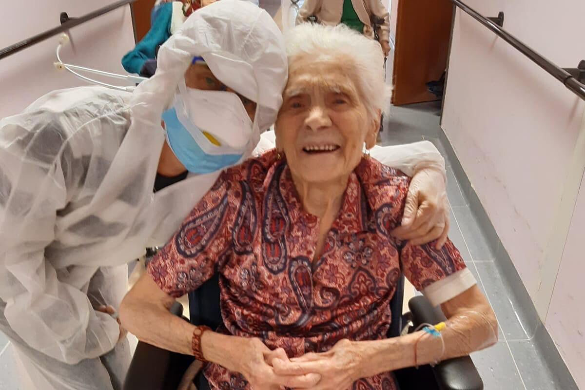 103-year-old Ada Zanusso smiles with a nurse on April 1 in Lessona, northern Italy, after recovering from COVID-19.