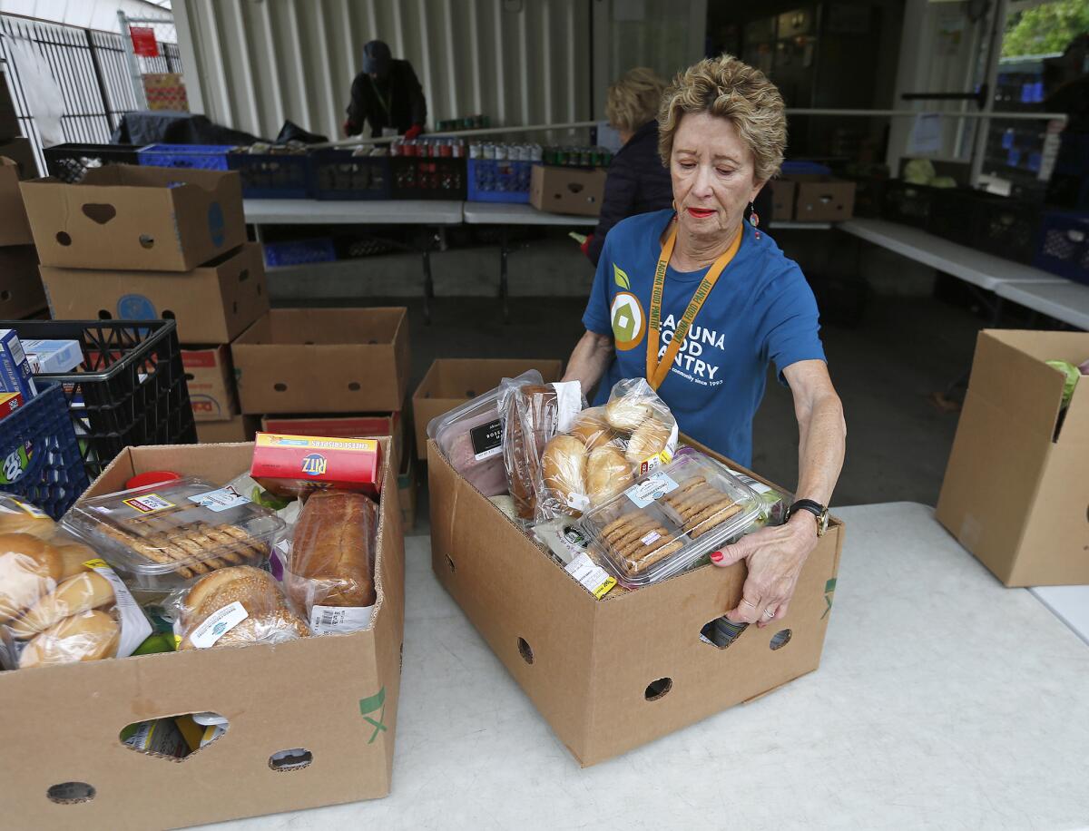 Volunteer box organizer Andrea Stein prepares for an approaching client at the Laguna Food Pantry on Wednesday.