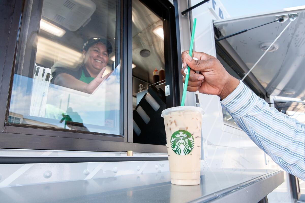 Starbucks barista Laura Rodriguez serves up a drink. The company will give away "Starbucks for Life" to select customers, entitling each to a free Starbucks drink or food item every day for 30 years.