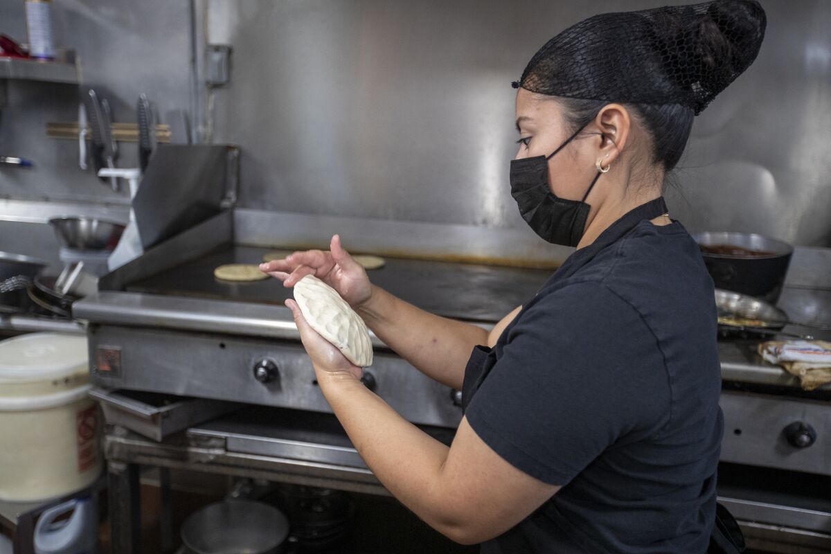 Yoana Flores makes pupusas at La Flor Blanca, owned by Alexis Navarrete, near USC.