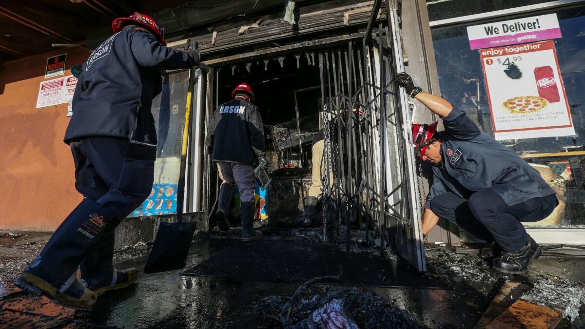 Arson investigators are working to determine what caused a fire in a strip mall in the South Park neighborhood of South Los Angeles that left two people dead Tuesday morning.