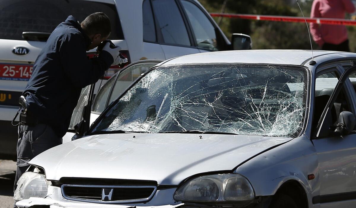 Israeli investigators inspect a car that plowed into pedestrians in Jerusalem on March 6.