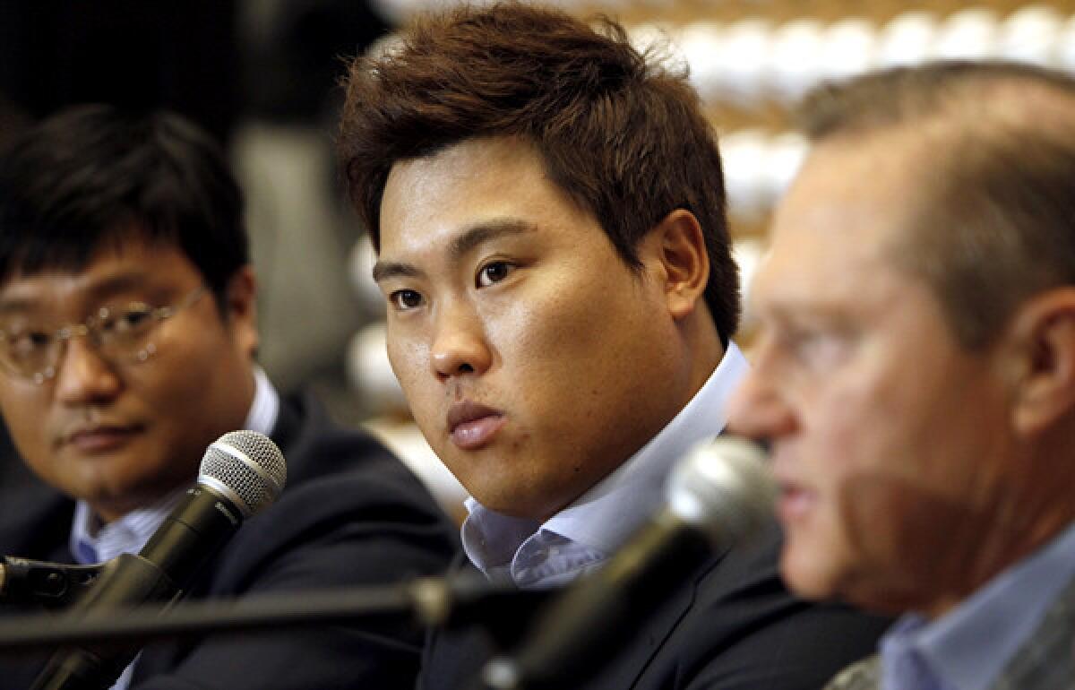 Pitcher Ryu Hyun-jin is flanked by agent Scott Boras, right, and Boras' South Korea representative Al Chung during a news conference Thursday in Newport Beach.