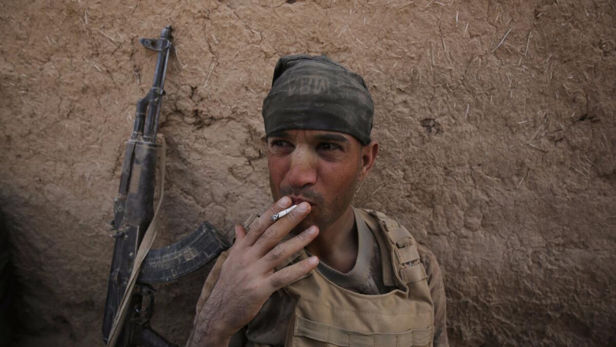 A member of Iraqi government forces rests in Al Khuwayn, south of Mosul, after the military recaptured the village from Islamic State on Sunday.