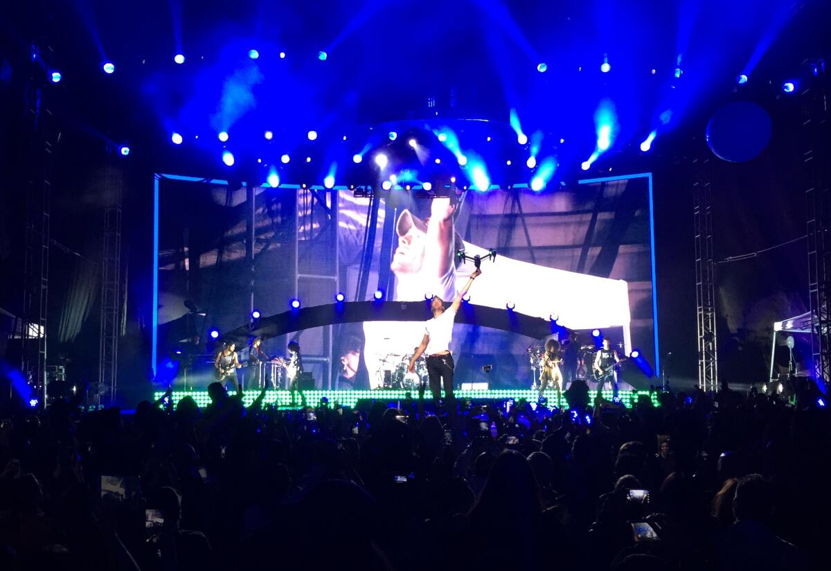 En esta imagen proporcionada por Francis Ramsden, Enrique Iglesias atrapa un dron en el escenario durante un concierto en Tijuana, México, el sábado 30 de mayo del 2015. El cantante, que se cortó varios dedos en esta hazaña, se sometió el lunes a una cirugía reconstructiva que "duró más de lo anticipado" porque sufrió también una fractura, dice un comunicado publicado en su cibersitio el martes. . (Francis Ramsden via AP)