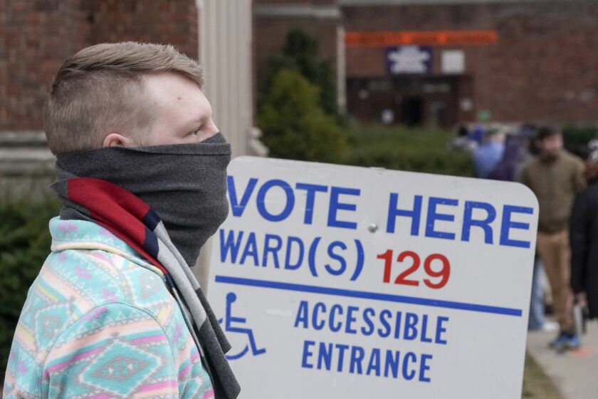 Voters masked against coronavirus line up at Riverside High School for Wisconsin's primary election Tuesday April 7, 2020, in Milwaukee. The new coronavirus causes mild or moderate symptoms for most people, but for some, especially older adults and people with existing health problems, it can cause more severe illness or death. (AP Photo/Morry Gash)