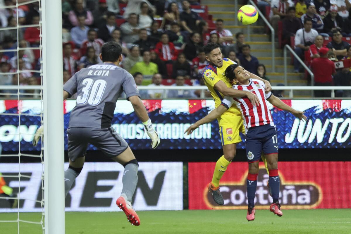 El jugador de Chivas Jesús Sánchez (d) disputa el balón con Henry Martín (i) de América hoy, sábado 3 de marzo de 2018, durante le juego correspondiente a la jornada 10 del torneo mexicano de fútbol celebrado en el estadio Akron en la ciudad de Guadalajara.