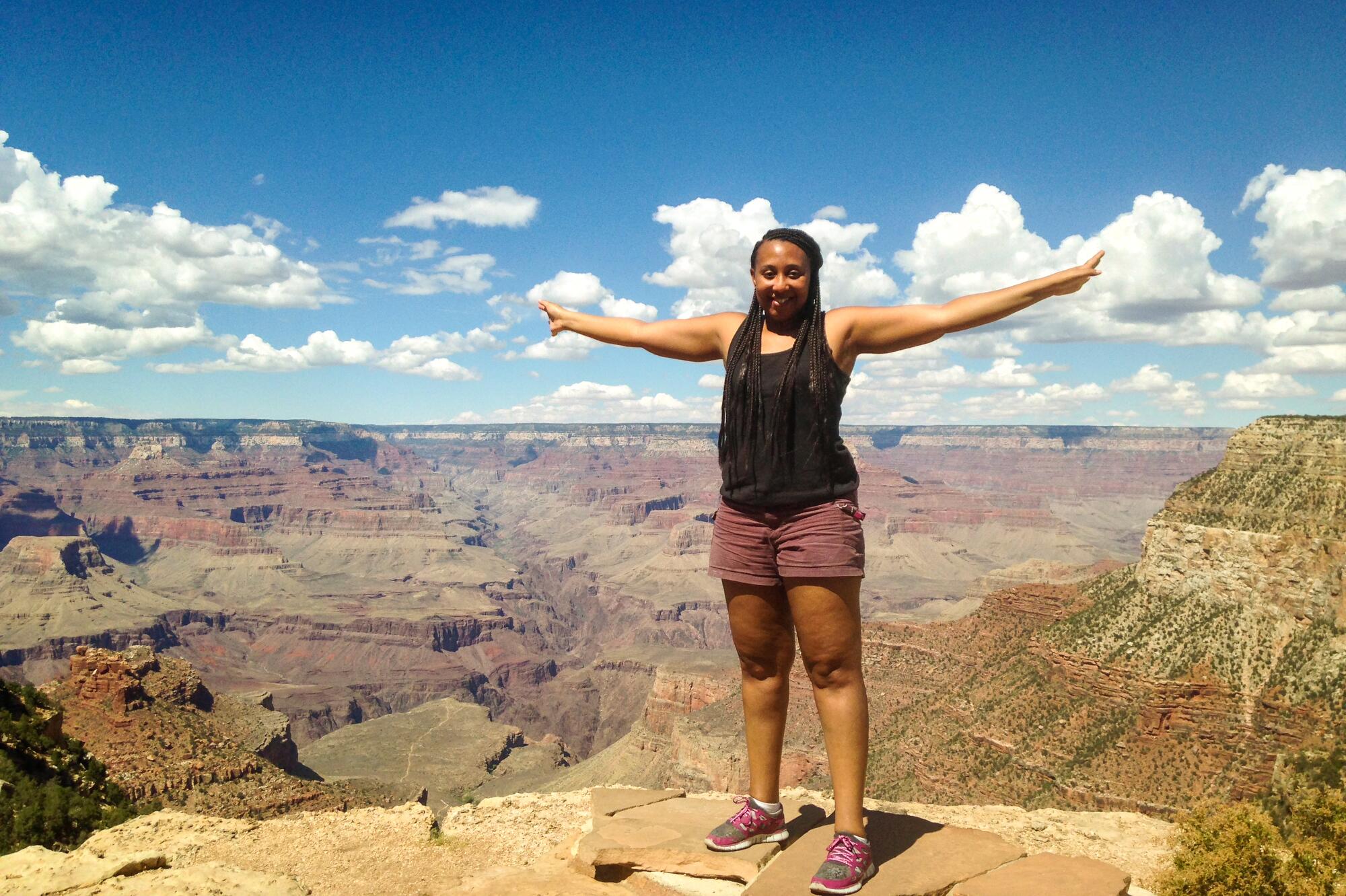 A woman lifts her arms in happiness