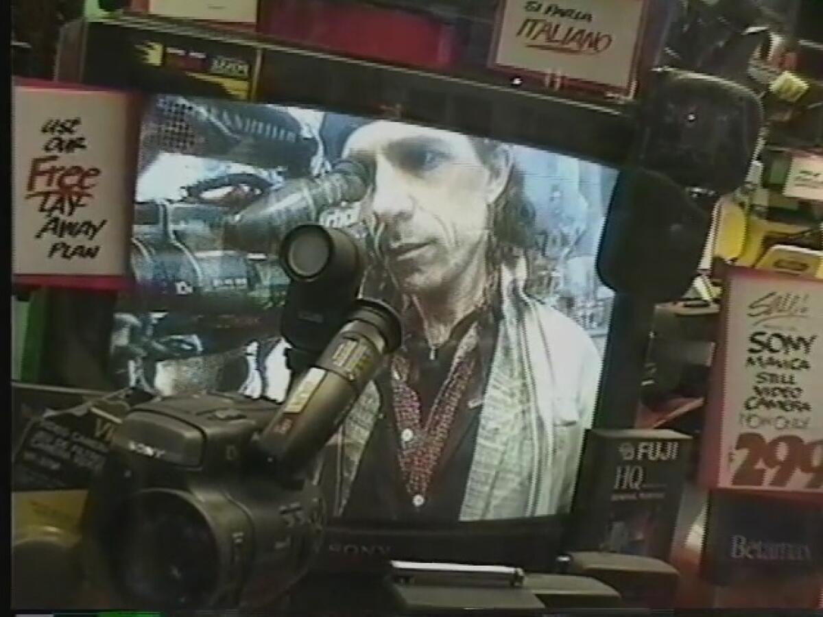 A videographer is captured on a TV set in an old shop.