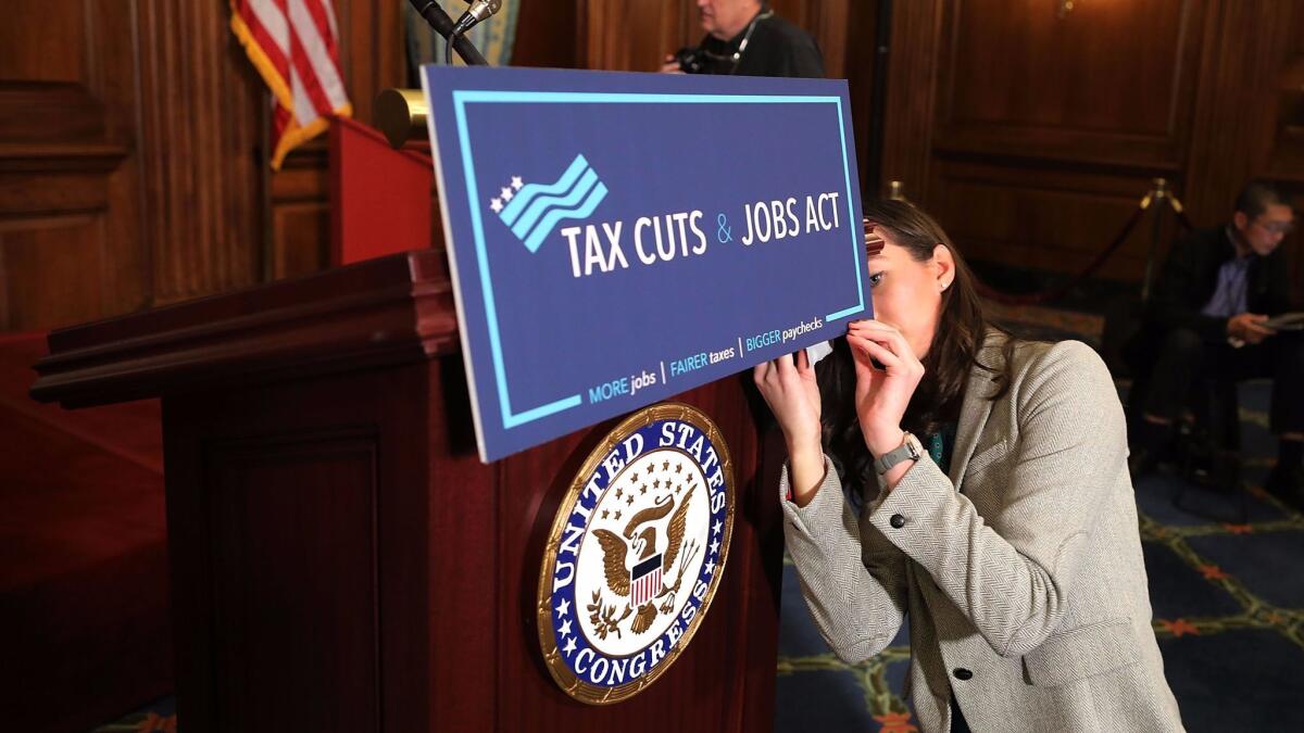 After the House passed the Republican tax bill, a congressional staff member prepares a sign before a Nov. 17 news conference held by Speaker Paul Ryan on Capitol Hill.